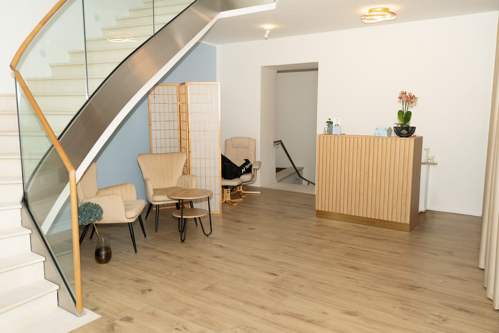 Der Empfang von SUSI in der Porzellangasse: helles Holz, ruhige Sitzecke, Treppe ins Galeriegeschoss